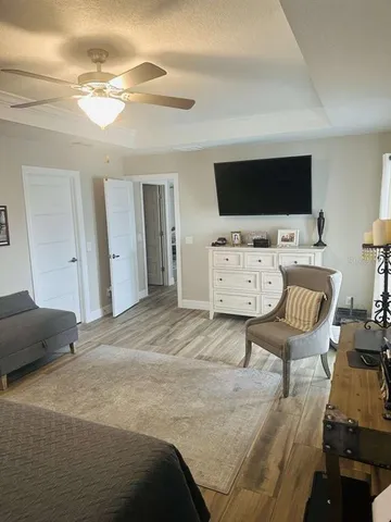 a spacious bedroom with a bed and a flat screen tv