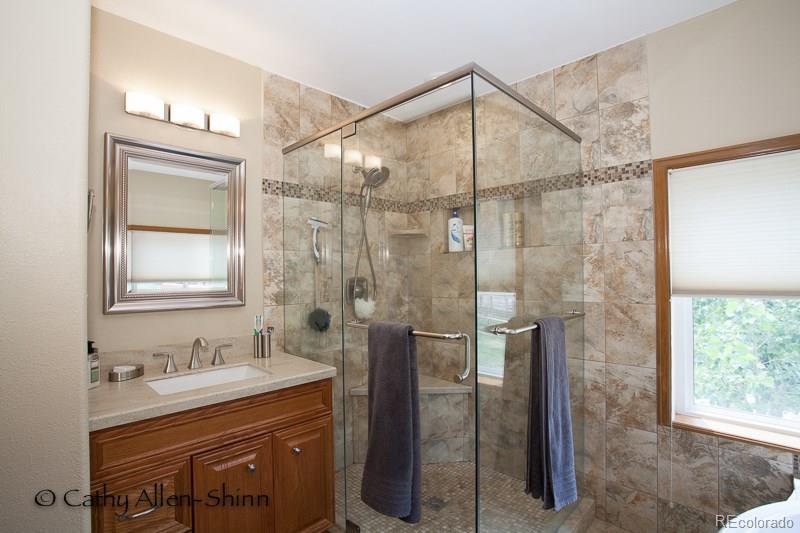 6202 Lorraine Road Larkspur, CO 80118 - Photo 28 of 35 a bathroom with a granite countertop sink a shower and a mirror