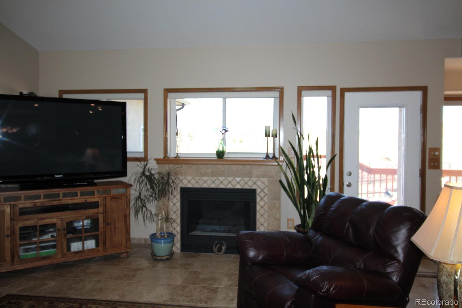 6202 Lorraine Road Larkspur, CO 80118 - Photo 9 of 35 a living room with furniture a flat screen tv and a fireplace