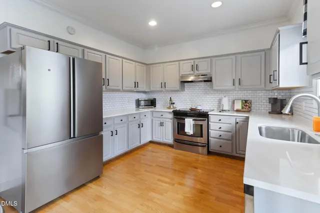 a kitchen with white cabinets appliances and sink
