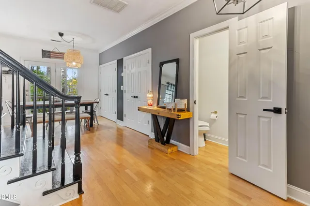 a hallway with wooden floor table and chairs