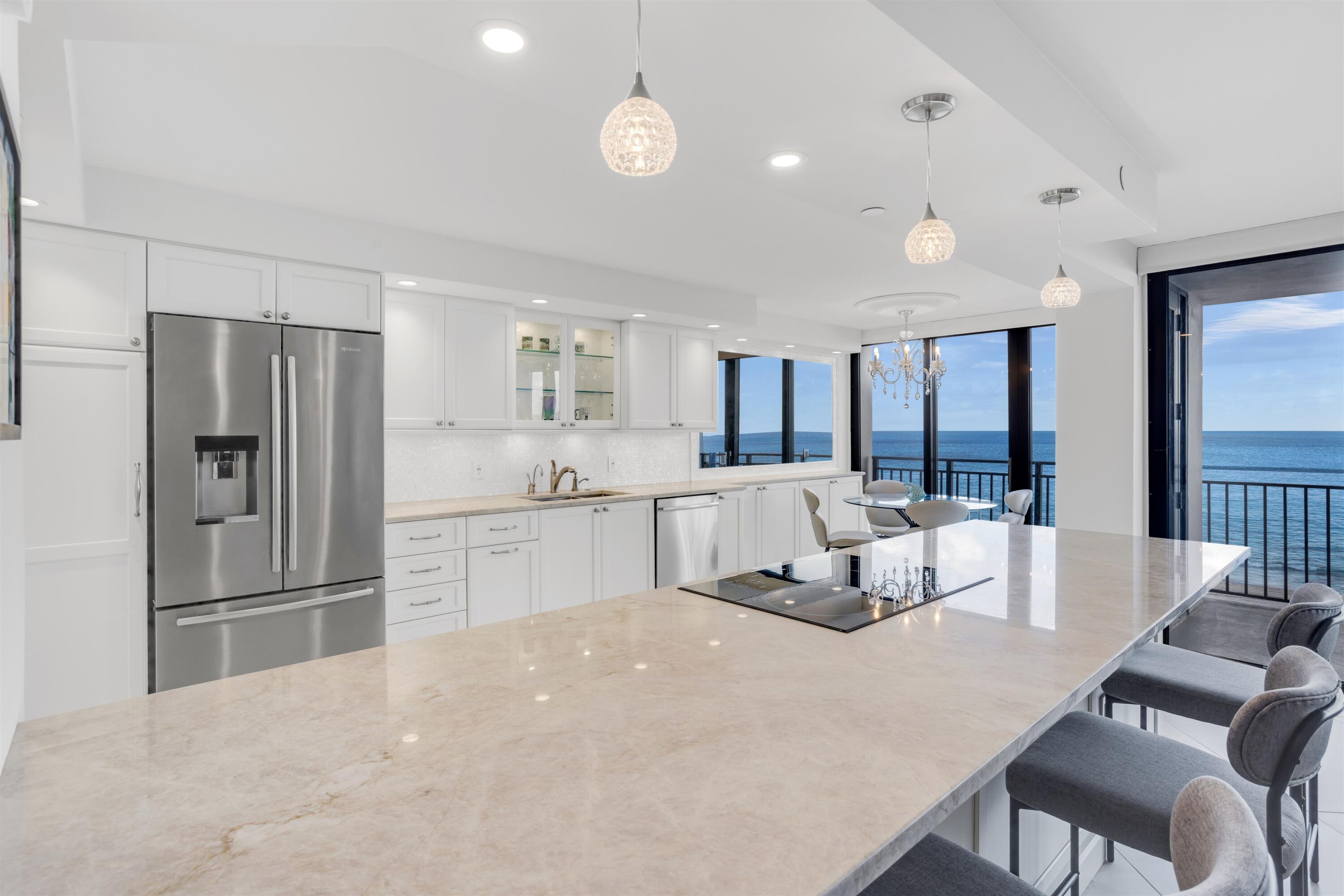 1800 South Ocean Boulevard, Unit 6B Boca Raton, FL 33432 - Photo 13 of 34 a large kitchen with stainless steel appliances a refrigerator a sink dishwasher a dining table and chairs with wooden floor