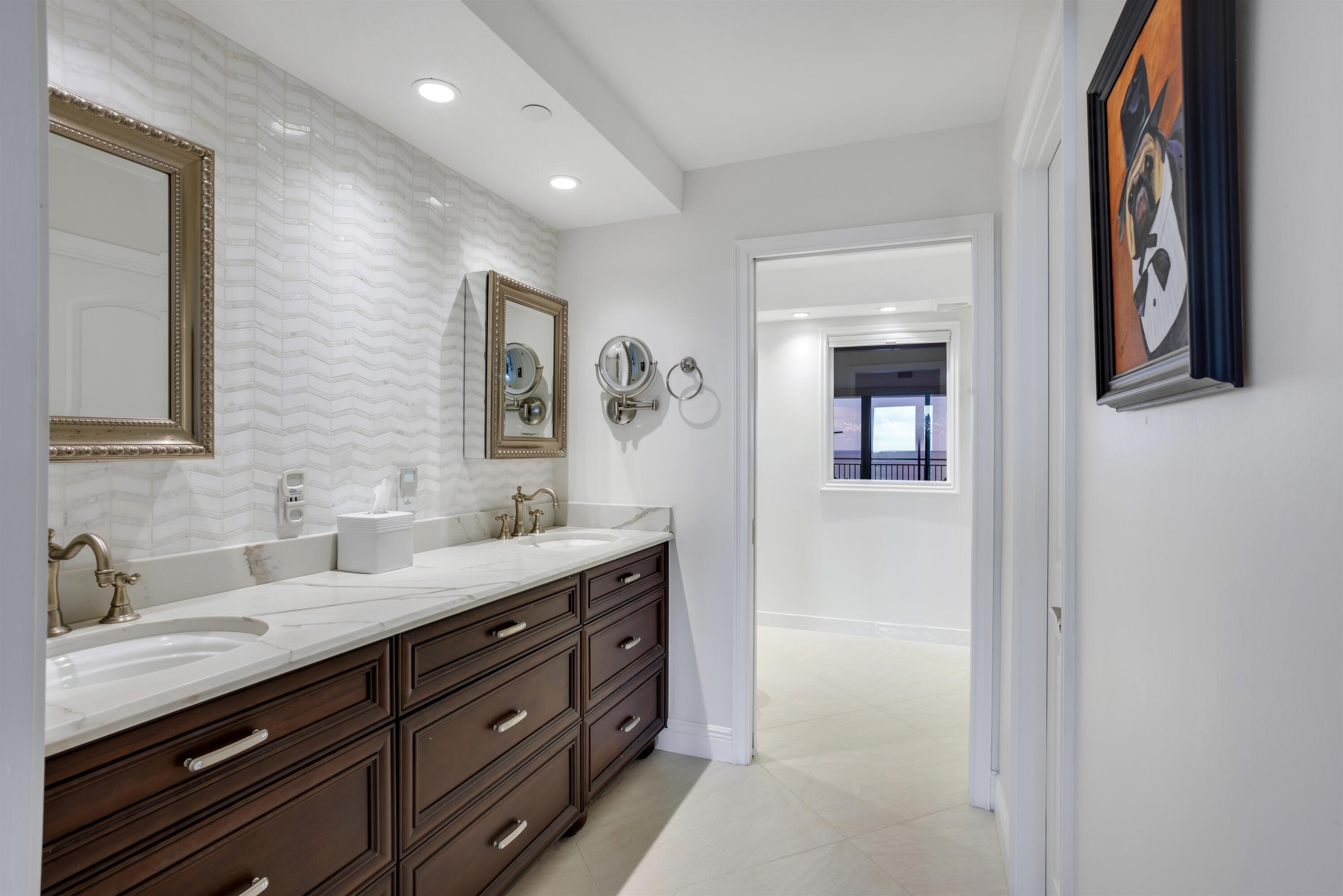 1800 South Ocean Boulevard, Unit 6B Boca Raton, FL 33432 - Photo 15 of 34 a bathroom with a double vanity sink and a mirror