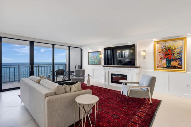 a living room with furniture a flat screen tv and a floor to ceiling window