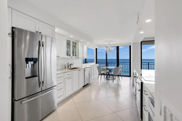 a kitchen with granite countertop a refrigerator a table and chairs