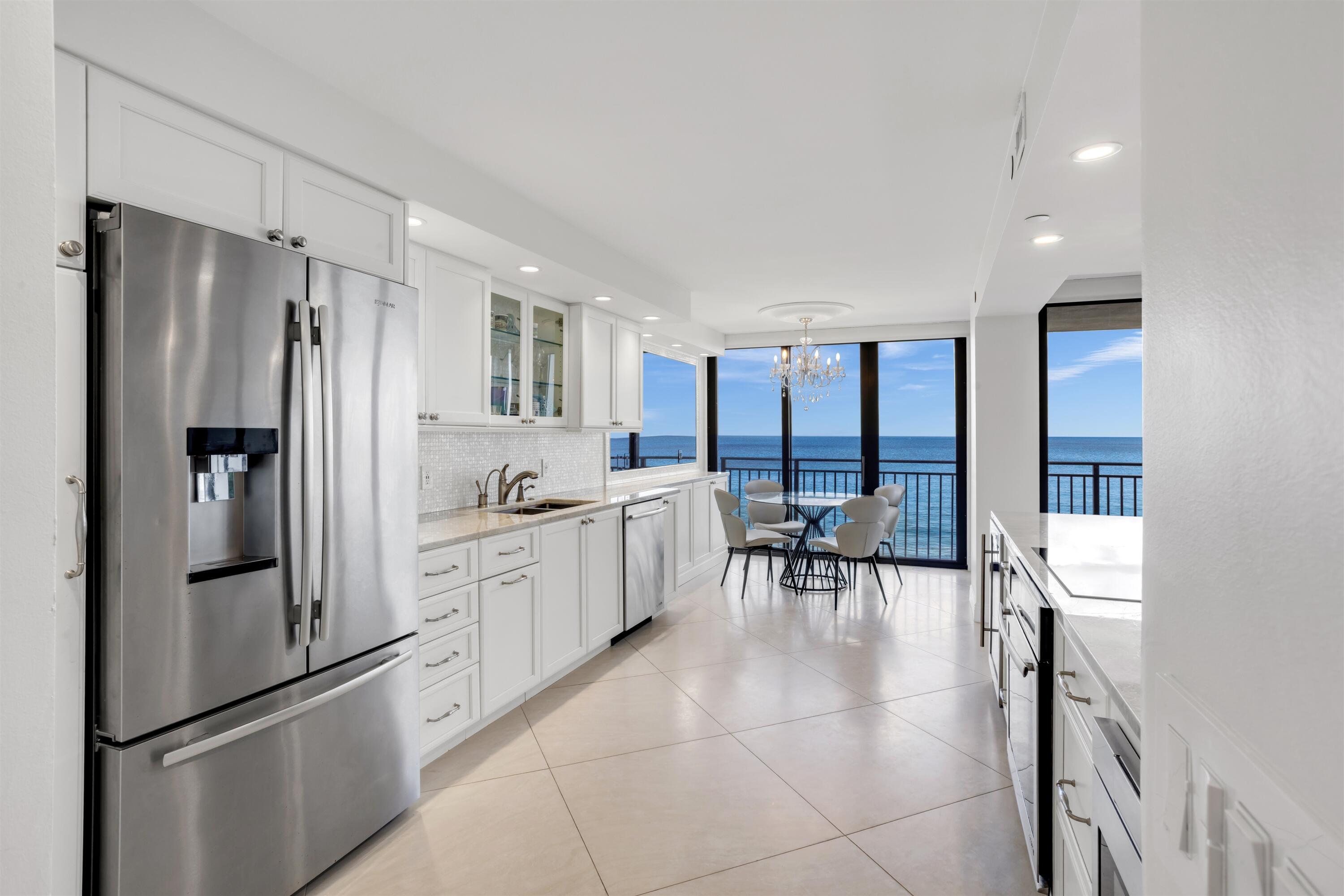 1800 South Ocean Boulevard, Unit 6B Boca Raton, FL 33432 - Photo 10 of 34 a kitchen with granite countertop a refrigerator a table and chairs
