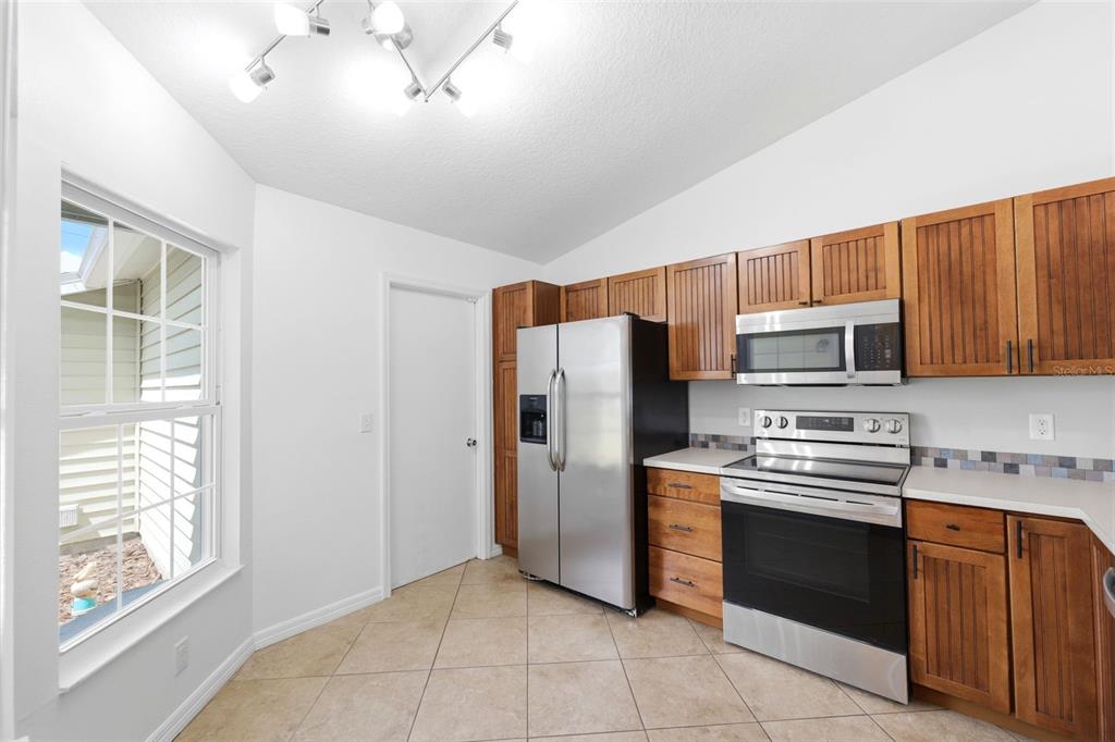 11224 Holbrook Street Spring Hill, FL 34609 - Photo 11 of 55 a kitchen with stainless steel appliances granite countertop a refrigerator and a stove top oven