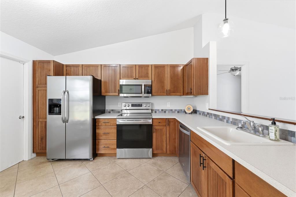 11224 Holbrook Street Spring Hill, FL 34609 - Photo 12 of 55 a kitchen with stainless steel appliances granite countertop a sink stove and refrigerator
