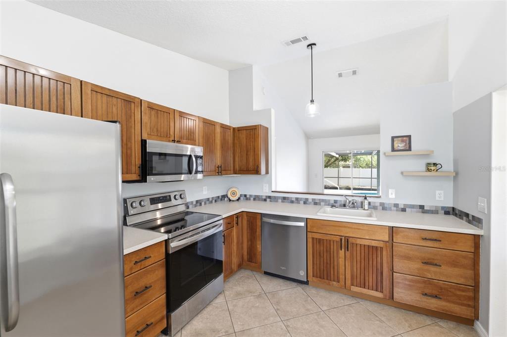 11224 Holbrook Street Spring Hill, FL 34609 - Photo 14 of 55 a kitchen with a sink stove and refrigerator