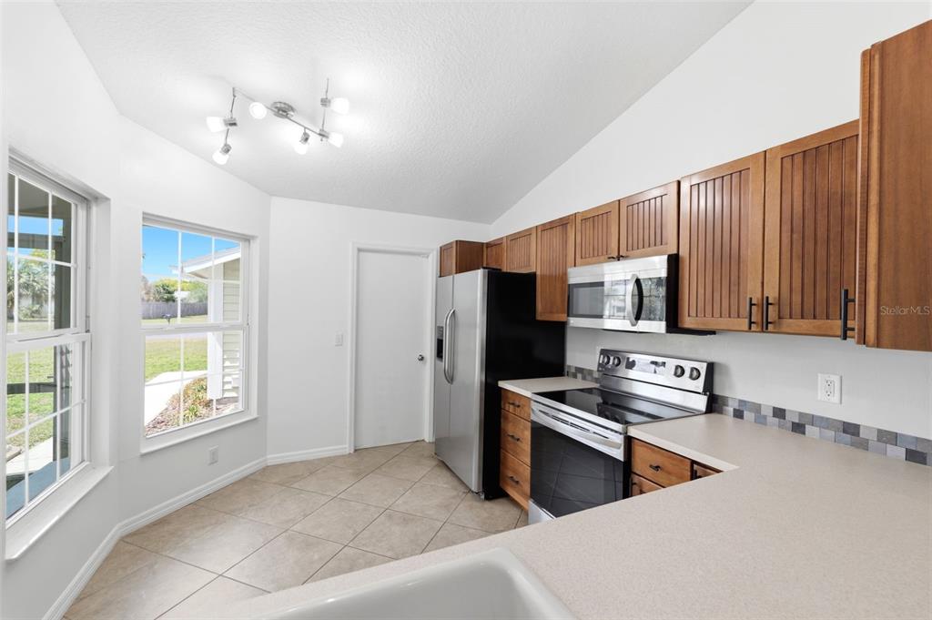 11224 Holbrook Street Spring Hill, FL 34609 - Photo 16 of 55 a kitchen that has a lot of cabinets and stainless steel appliances