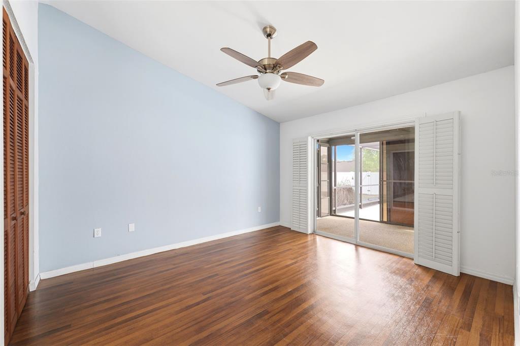 11224 Holbrook Street Spring Hill, FL 34609 - Photo 19 of 55 a view of an empty room with wooden floor and a window