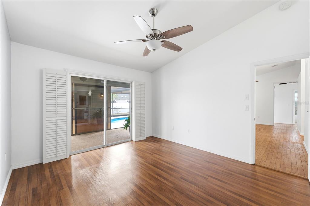 11224 Holbrook Street Spring Hill, FL 34609 - Photo 20 of 55 a view of an empty room with wooden floor and a window