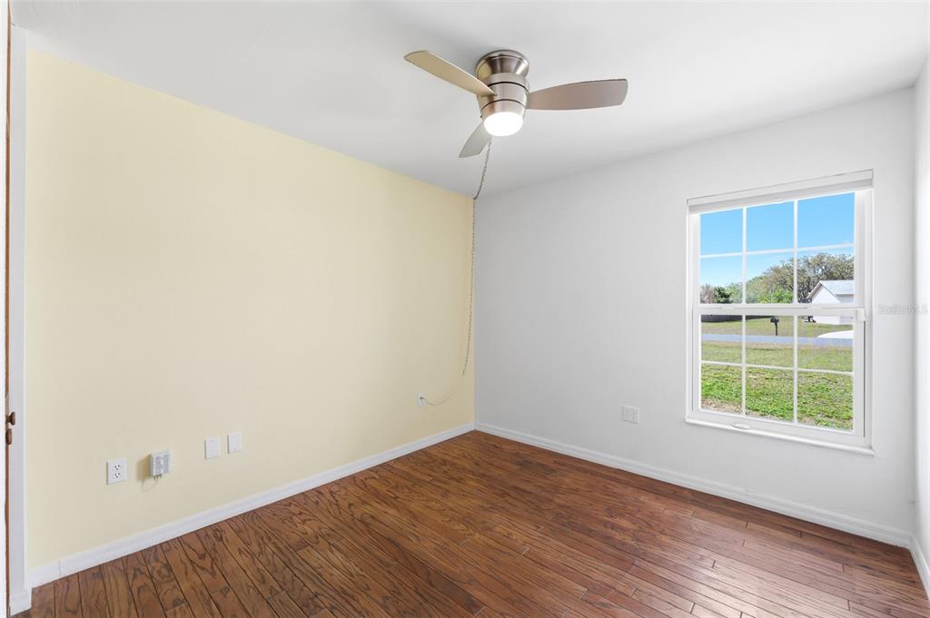 11224 Holbrook Street Spring Hill, FL 34609 - Photo 24 of 55 an empty room with a window and wooden floor