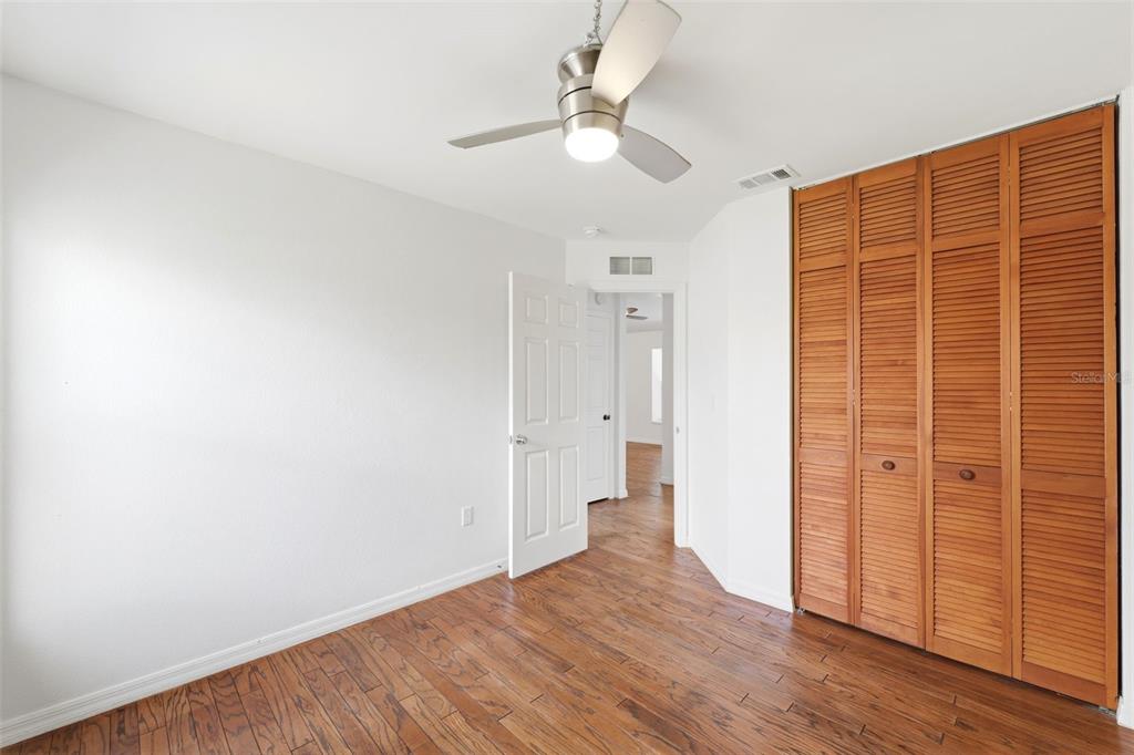 11224 Holbrook Street Spring Hill, FL 34609 - Photo 25 of 55 an empty room with wooden floor closet and windows
