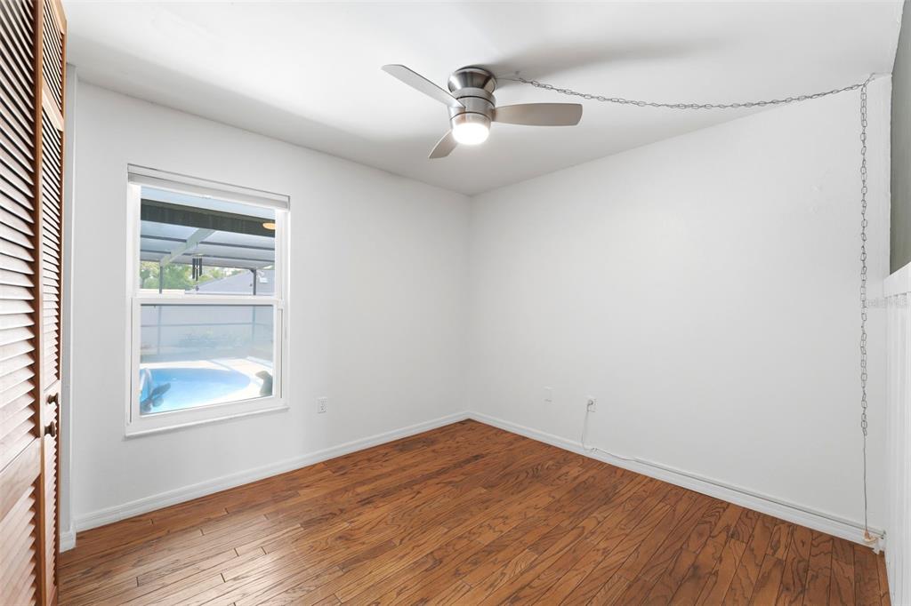 11224 Holbrook Street Spring Hill, FL 34609 - Photo 27 of 55 an empty room with a window and wooden floor