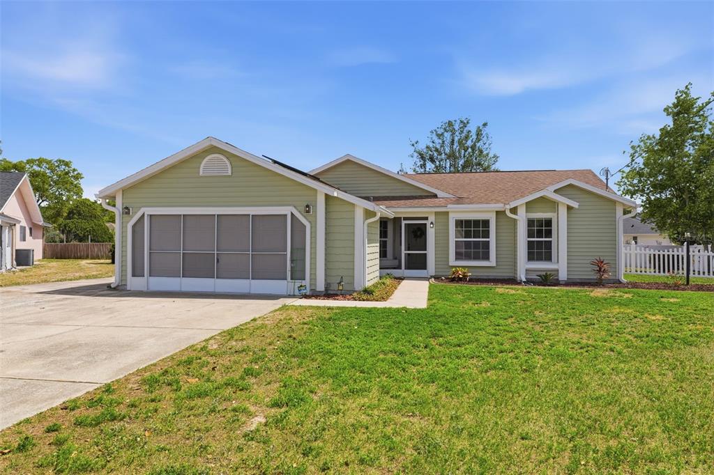 11224 Holbrook Street Spring Hill, FL 34609 - Photo 4 of 55 front view of a house with a garden