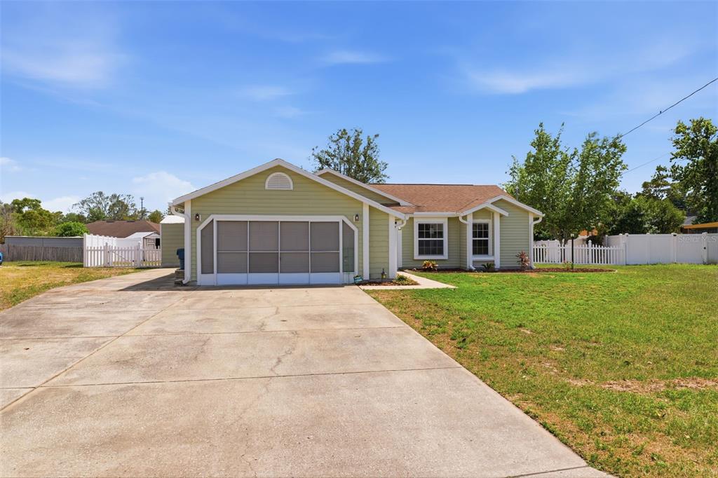 11224 Holbrook Street Spring Hill, FL 34609 - Photo 42 of 55 a front view of a house with a garden