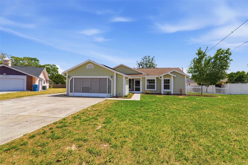 11224 Holbrook Street Spring Hill, FL 34609 - Photo 45 of 55 a front view of a house with a garden