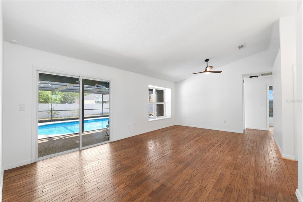 11224 Holbrook Street Spring Hill, FL 34609 - Photo 8 of 55 an empty room with wooden floor and windows