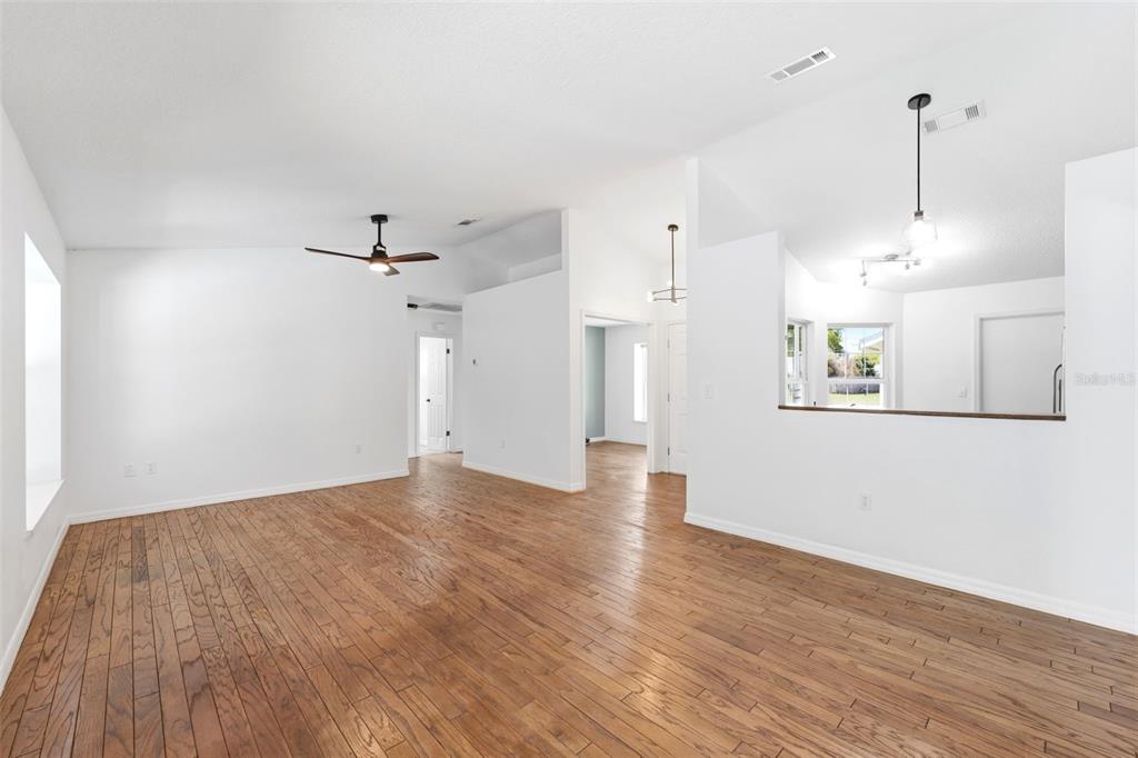 11224 Holbrook Street Spring Hill, FL 34609 - Photo 9 of 55 a view of an empty room with wooden floor and a window