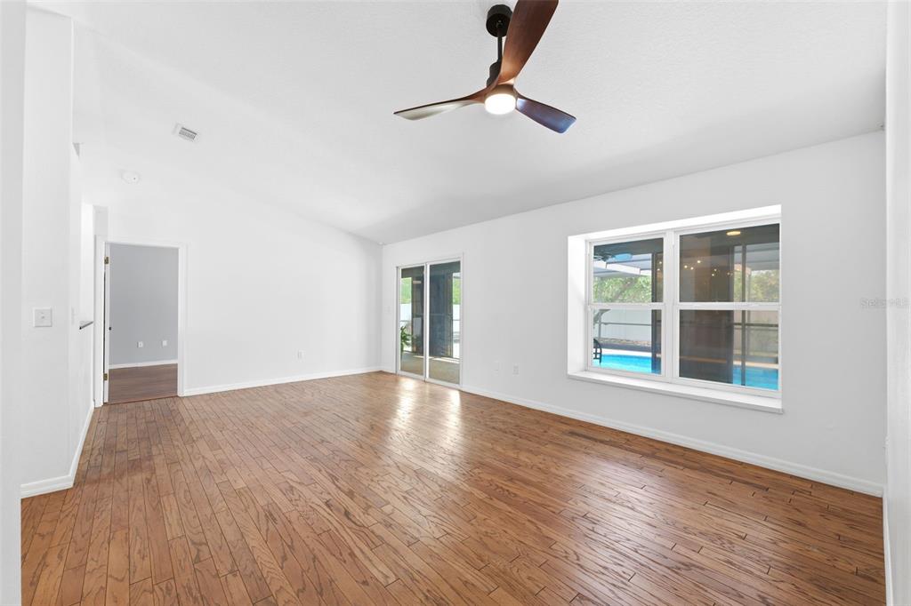 11224 Holbrook Street Spring Hill, FL 34609 - Photo 10 of 55 a view of an empty room with window and wooden floor