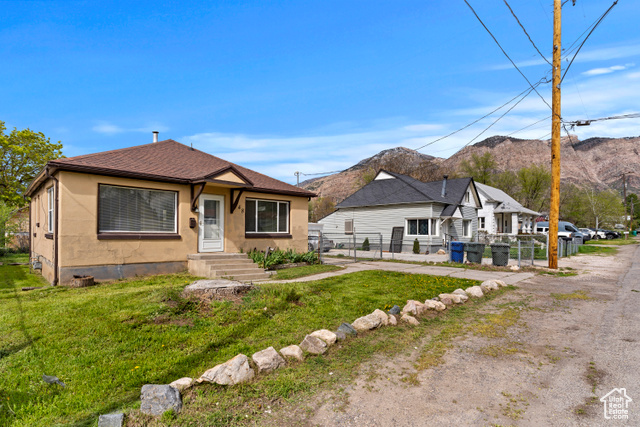 View of front facade with a mountain view and a front lawn