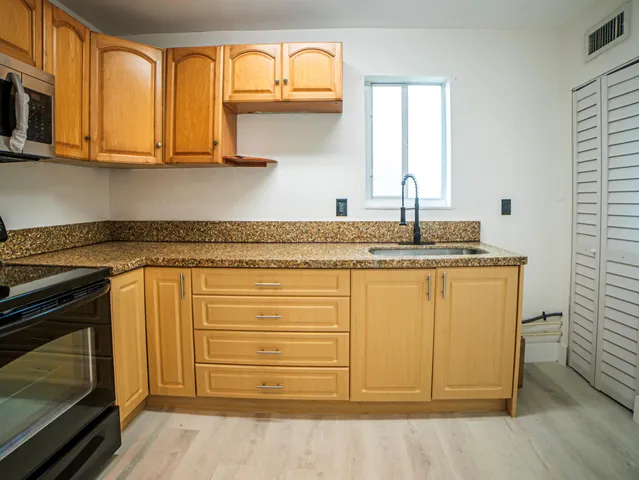 a view of a kitchen with a sink and a refrigerator