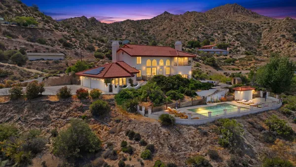 a aerial view of a house with a garden and mountains