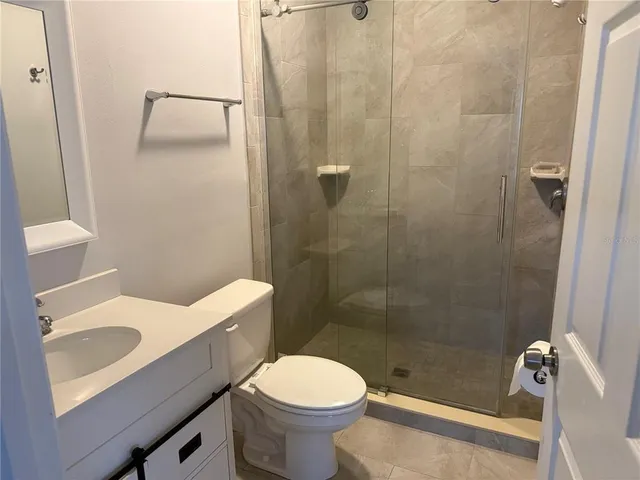 a white toilet sitting next to a bath tub and a shower
