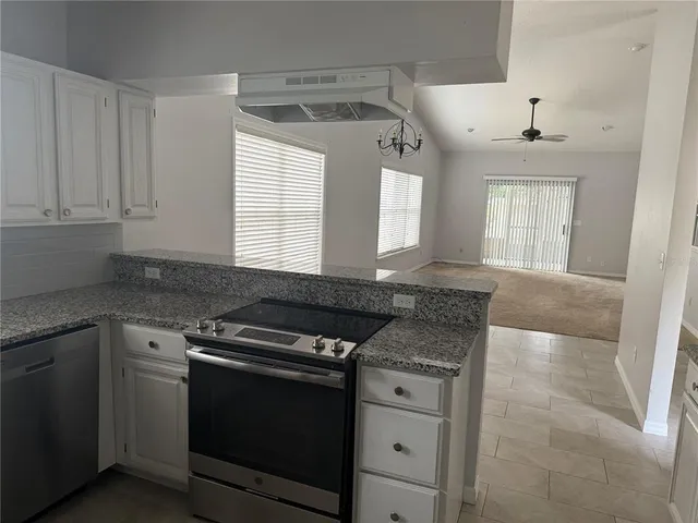a kitchen with granite countertop a stove and a sink