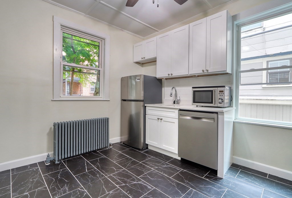 15-17 Pond Street Boston, MA 02130 - Photo 14 of 21 a kitchen with a refrigerator a stove a microwave and cabinets