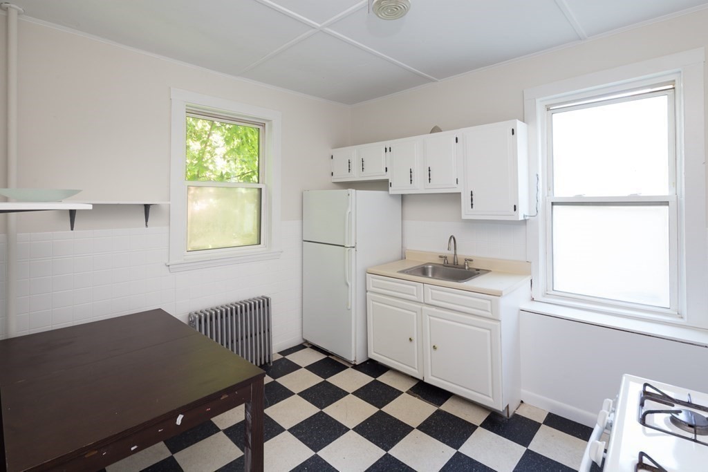 15-17 Pond Street Boston, MA 02130 - Photo 18 of 21 a kitchen with a sink a window and cabinets