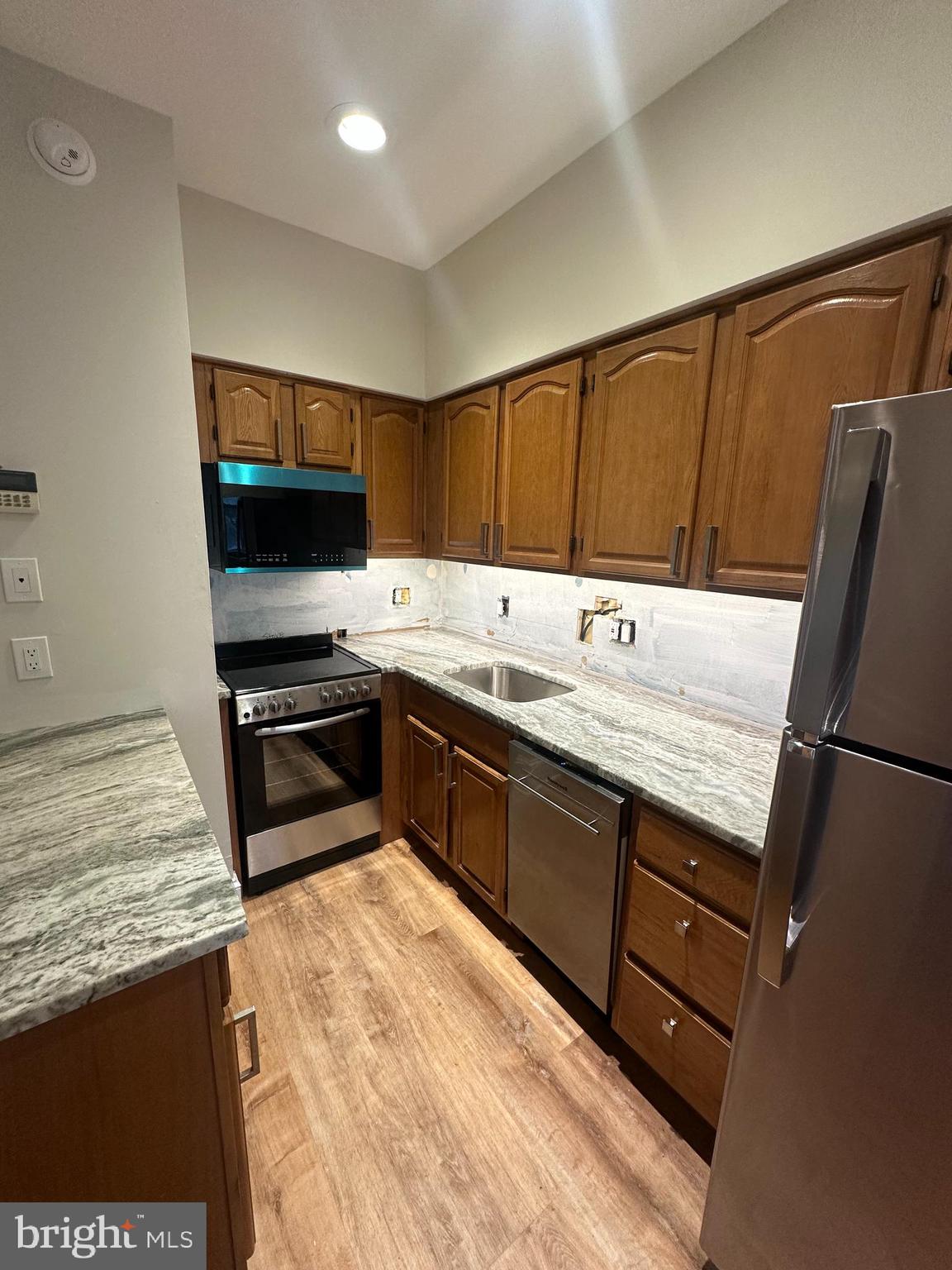 a kitchen with stainless steel appliances sink stove microwave and refrigerator