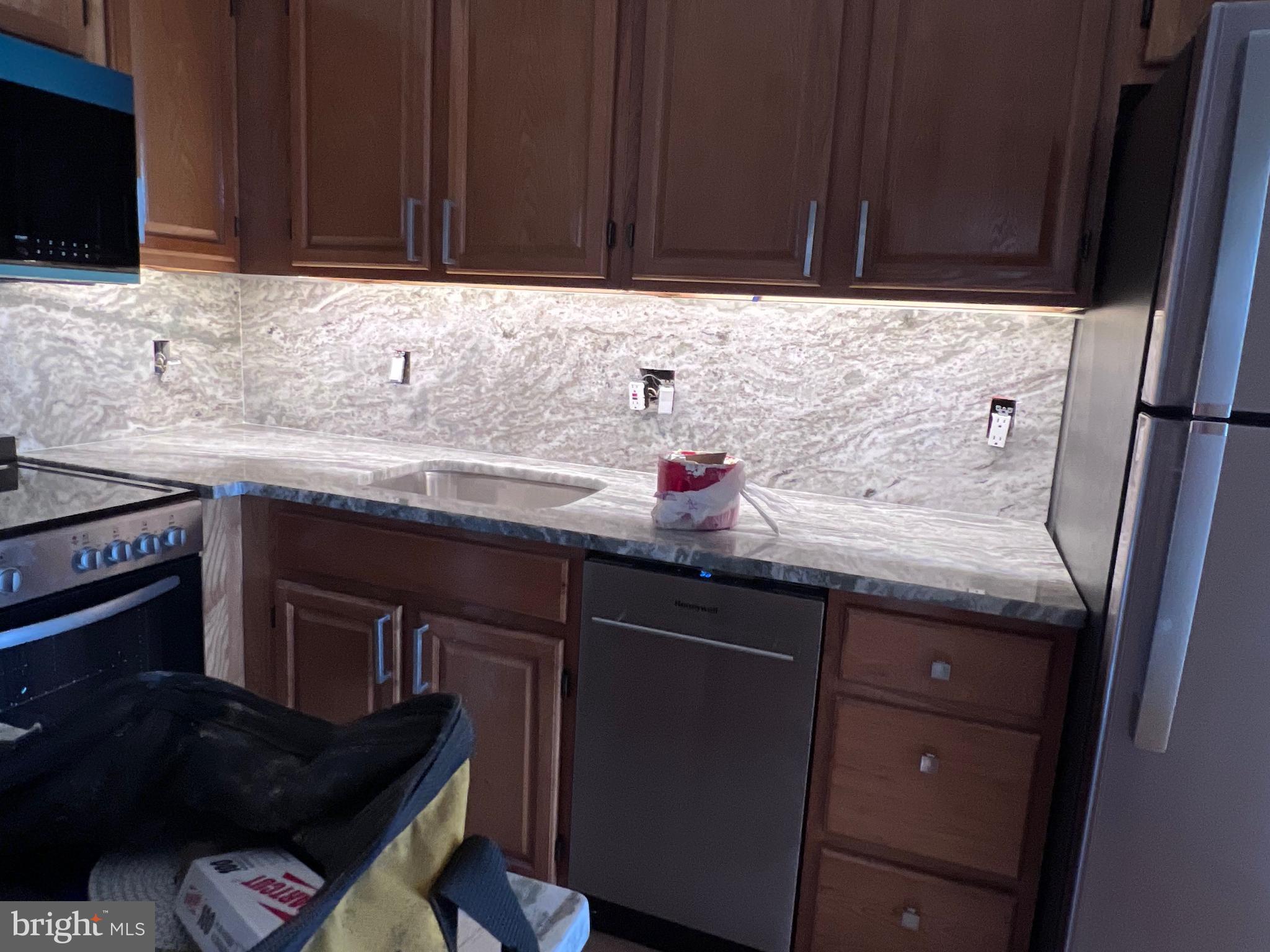 1306 West 13th Street, Unit 1 Wilmington, DE 19806 - Photo 5 of 21 a kitchen with granite countertop a sink dishwasher stove and cabinets