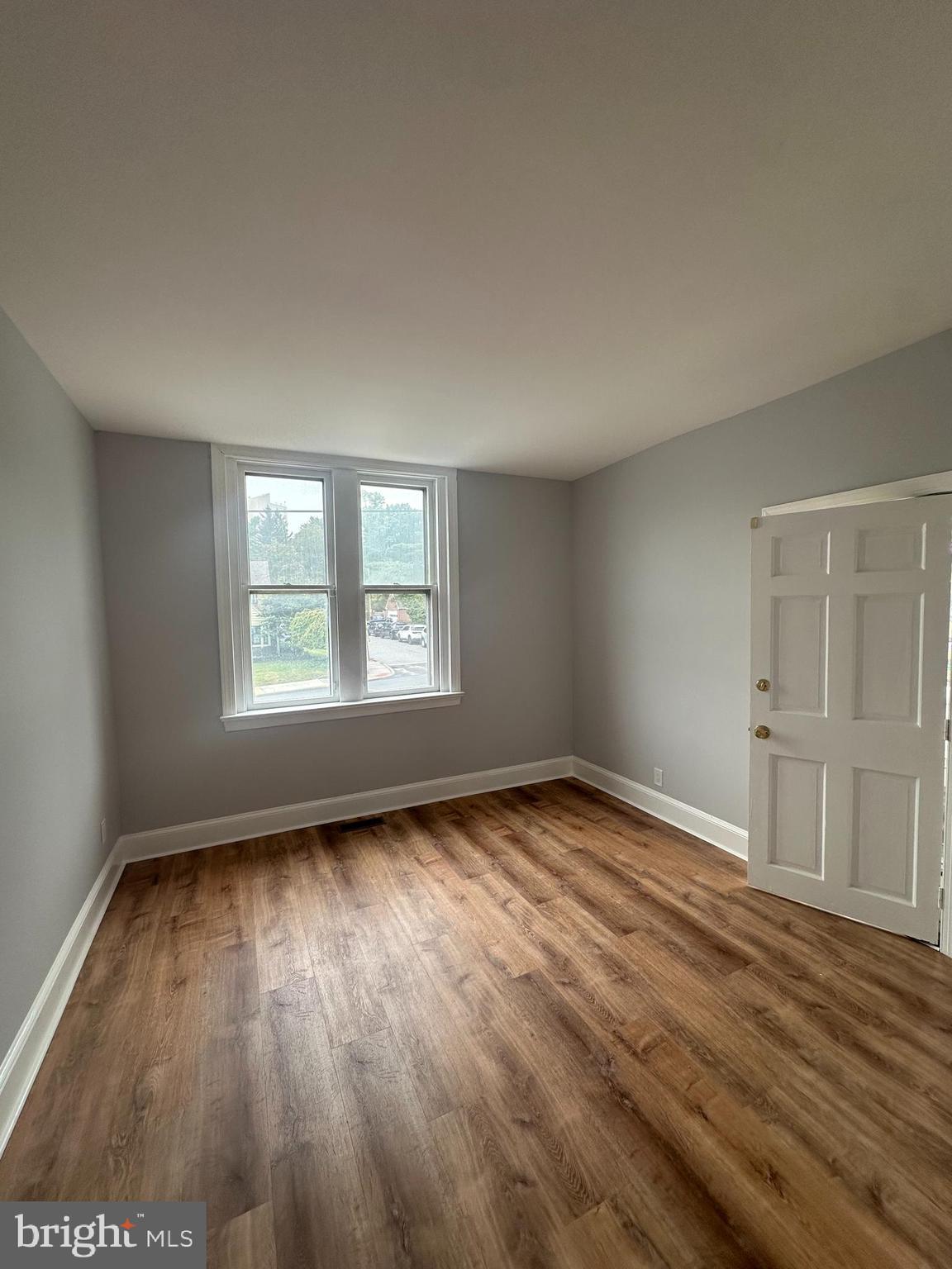 1306 West 13th Street, Unit 1 Wilmington, DE 19806 - Photo 9 of 21 an empty room with wooden floor and windows