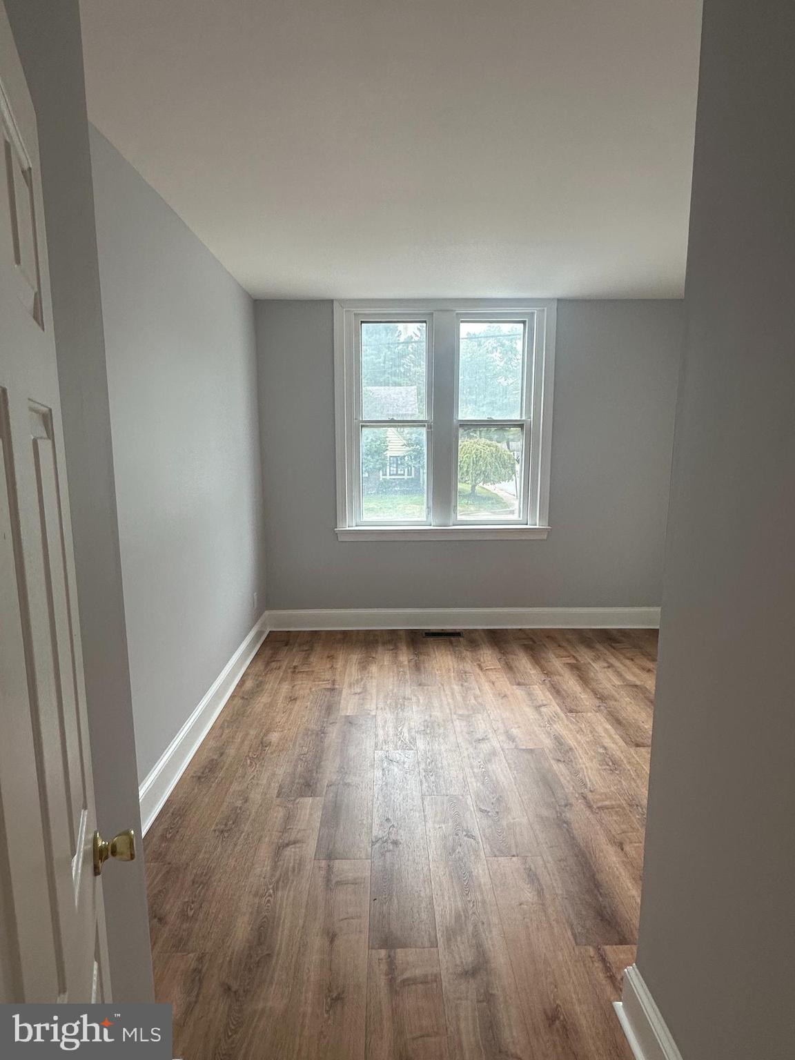 1306 West 13th Street, Unit 1 Wilmington, DE 19806 - Photo 10 of 21 an empty room with wooden floor and windows