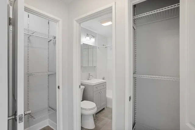 a bathroom with a granite countertop toilet a sink and a mirror