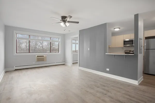 a view of empty room with a fireplace and wooden floor