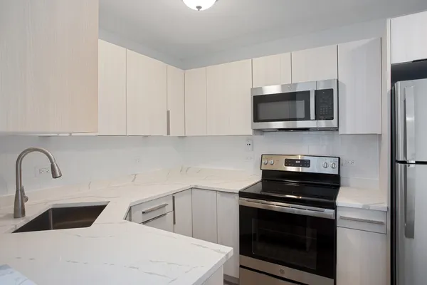 a kitchen with sink a microwave and cabinets