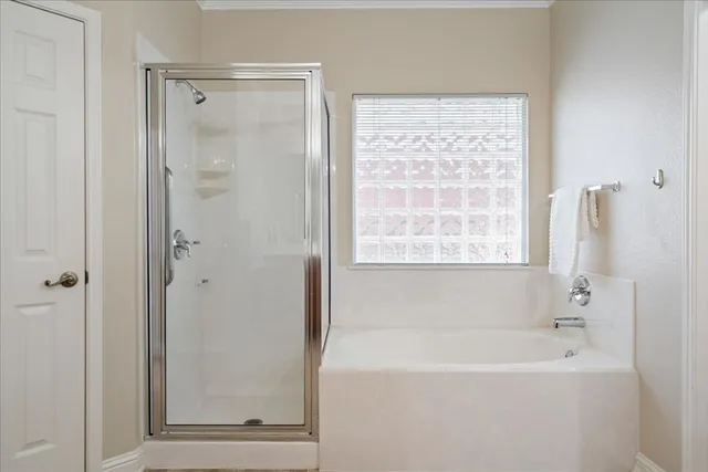 a bedroom with a bed and large windows