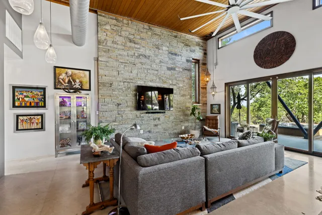 a living room with furniture a large window and a fireplace