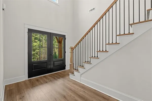 a view of a hallway with wooden floor and stairs
