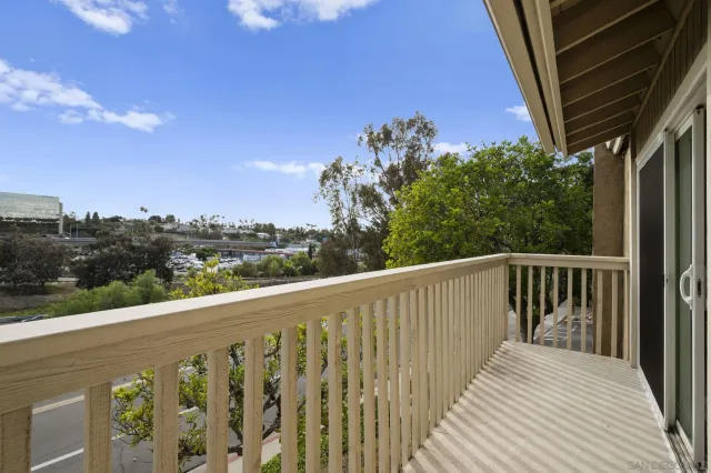 a balcony with wooden floor and city view