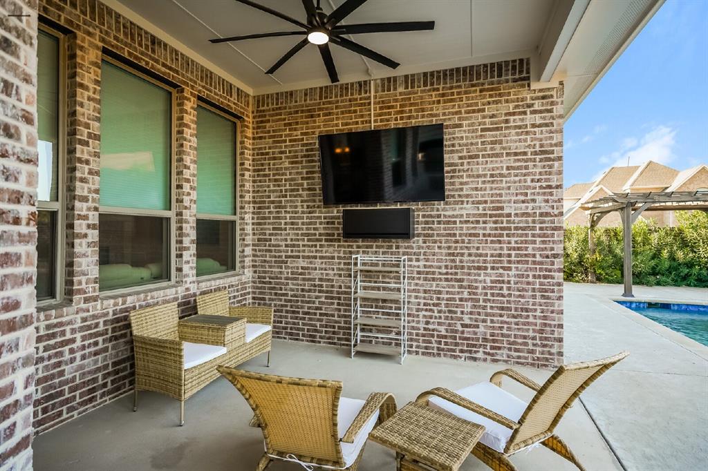 2000 Johnson Road Mansfield, TX 76063 - Photo 12 of 27 Covered patio featuring a ceiling fan, brick exterior, and a nearby swimming pool