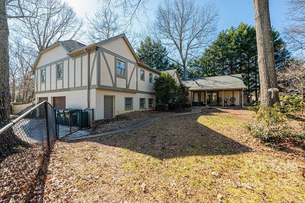 1761 4th St Circle Northeast Hickory, NC 28601 - Photo 8 of 48 a view of a white house with a large yard and lawn chairs under an umbrella