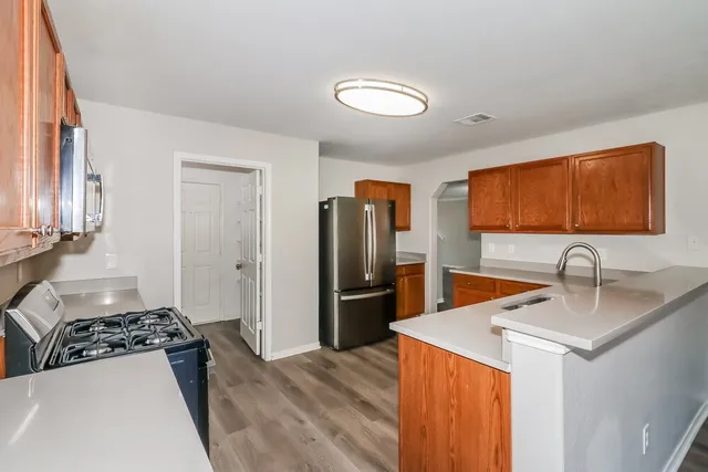a kitchen with stainless steel appliances granite countertop a sink stove and refrigerator