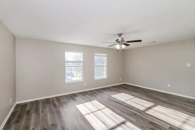 wooden floor in an empty room with a window