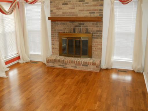 36166 North Edgewater Court Gurnee, IL 60031 - Photo 3 of 12 a view of an empty room with wooden floor and a fireplace