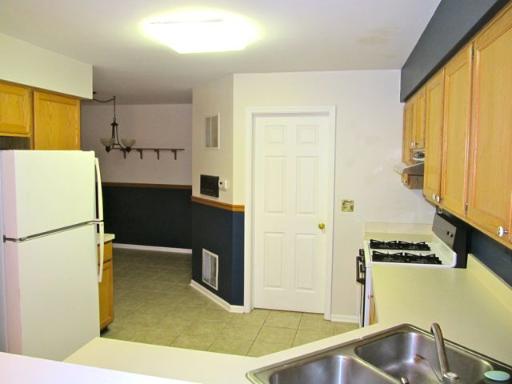 36166 North Edgewater Court Gurnee, IL 60031 - Photo 7 of 12 a kitchen with a refrigerator a stove top oven a sink and cabinets
