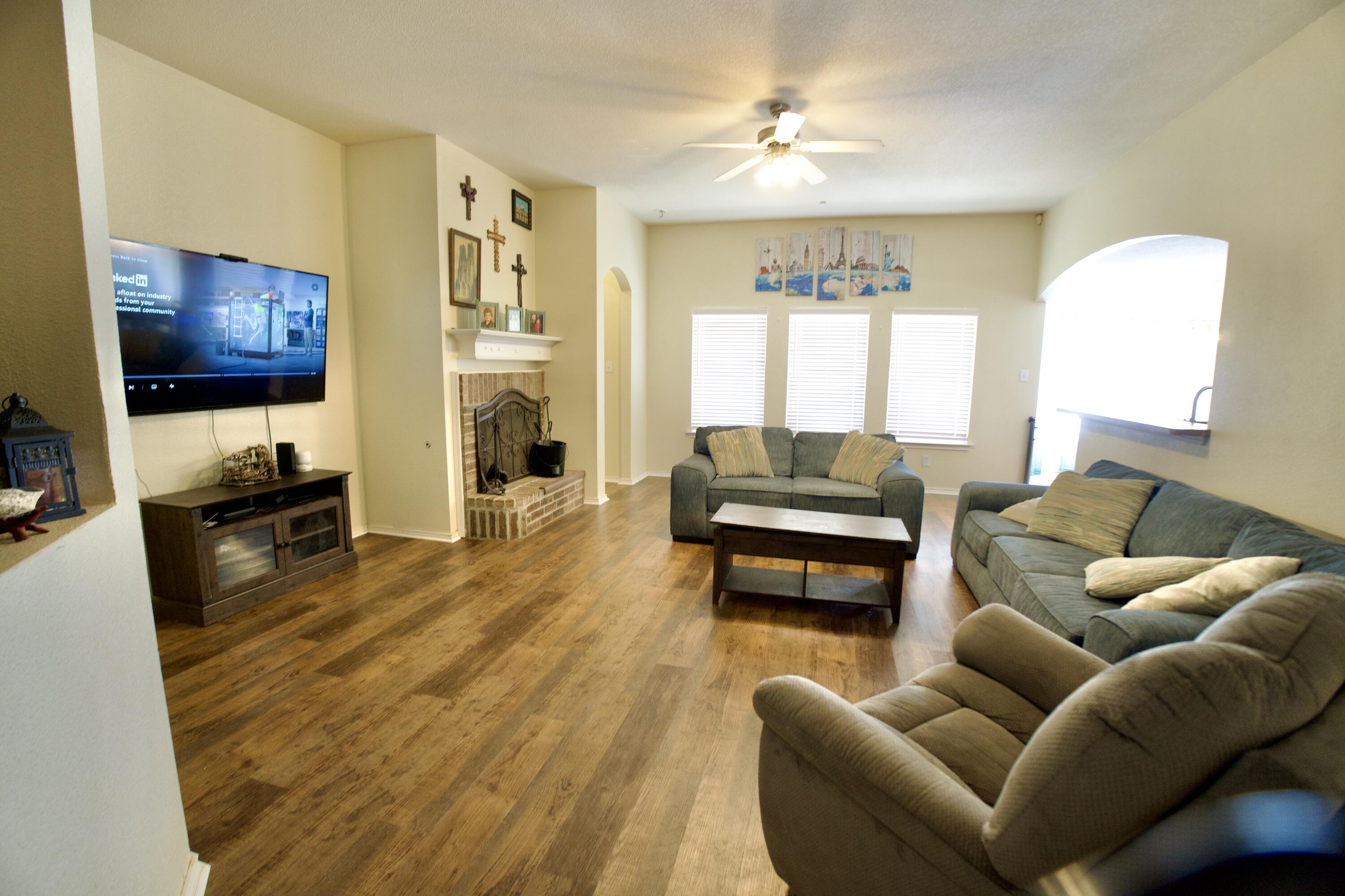 8811 16th Street Lubbock, TX 79416 - Photo 2 of 17 a living room with furniture and a flat screen tv